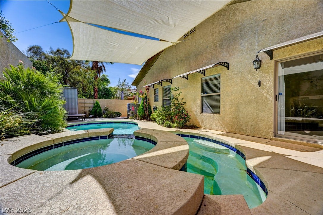 115 Cora Hills Court, Las Vegas, NV 89148 An inviting backyard oasis offers a sparkling pool under a sunshade.