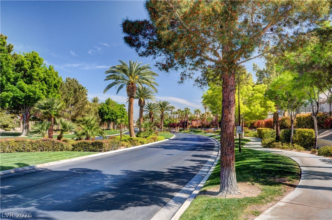 115 Cora Hills Court, Las Vegas, NV 89148 Lush landscaping and mature trees frame this scenic residential street with a gracefully curving sidewalk.