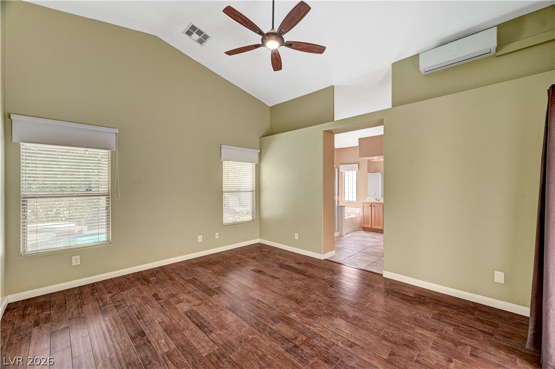 115 Cora Hills Court, Las Vegas, NV 89148 Hardwood floors and soaring vaulted ceilings define this peaceful primary bedroom, with a private bathroom access.