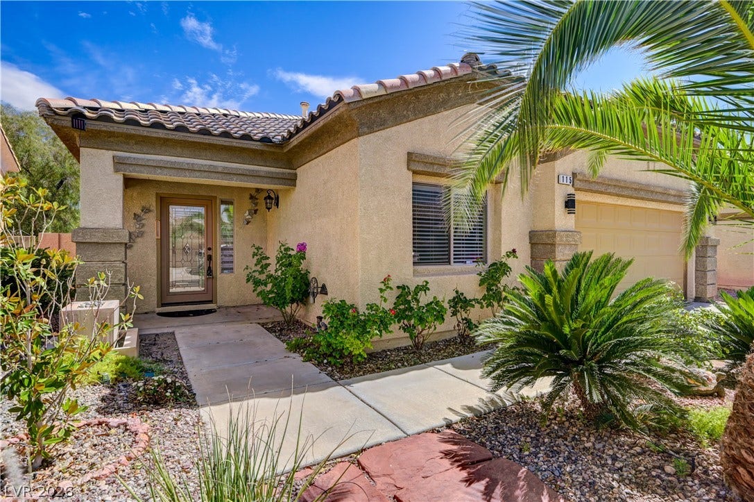 115 Cora Hills Court, Las Vegas, NV 89148 A desert-friendly landscape surrounds this welcoming home with a decorative glass front entry and a convenient garage.