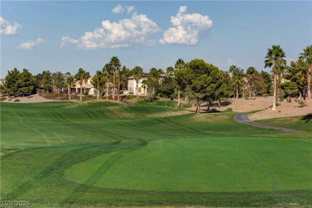 115 Cora Hills Court, Las Vegas, NV 89148 A verdant golf course stretches toward luxurious homes nestled amongst a variety of mature trees and landscaping.