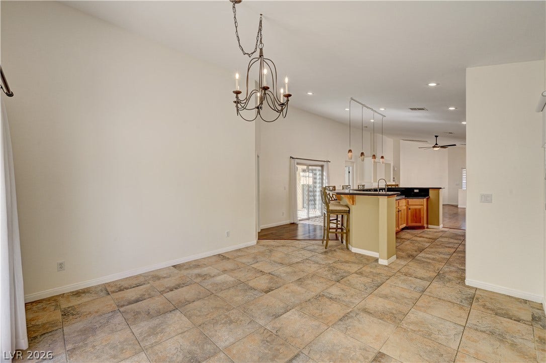 115 Cora Hills Court, Las Vegas, NV 89148 A spacious dining area seamlessly transitions into a bright kitchen with a convenient breakfast bar.