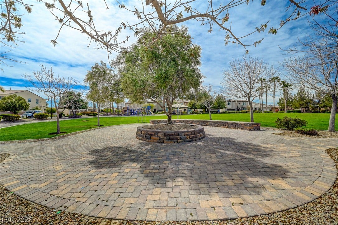 115 Cora Hills Court, Las Vegas, NV 89148 An inviting stone-paved patio offers a tranquil spot to enjoy the lush community green space and clear skies.
