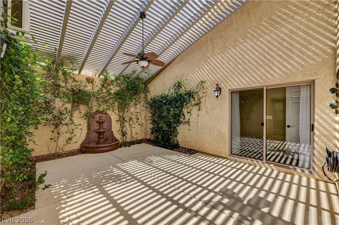115 Cora Hills Court, Las Vegas, NV 89148 A tranquil covered patio offers an outdoor water feature and verdant climbing plants.