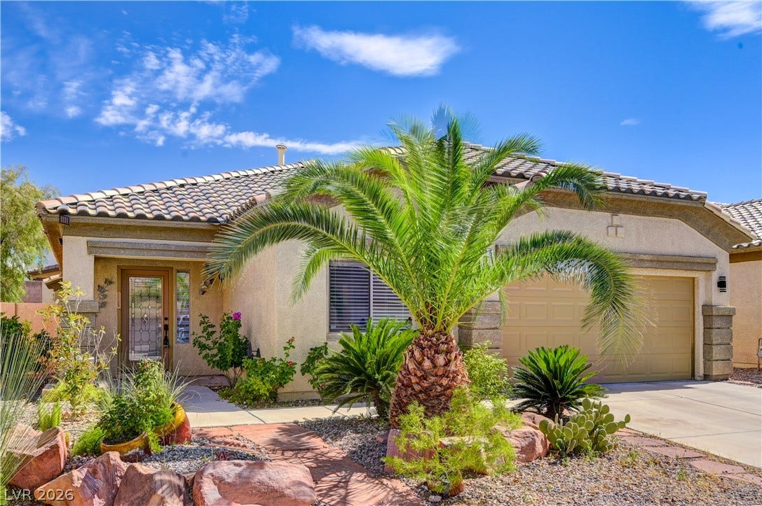 115 Cora Hills Court, Las Vegas, NV 89148 A terracotta tile roof crowns this home with desert landscaping and an attached garage.