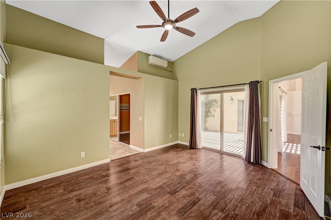 115 Cora Hills Court, Las Vegas, NV 89148 Hardwood floors and vaulted ceilings create an inviting bedroom with outdoor access.