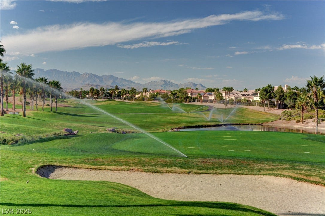 115 Cora Hills Court, Las Vegas, NV 89148 Green fairways and a serene pond are surrounded by palm trees and distant mountains on this community golf course.