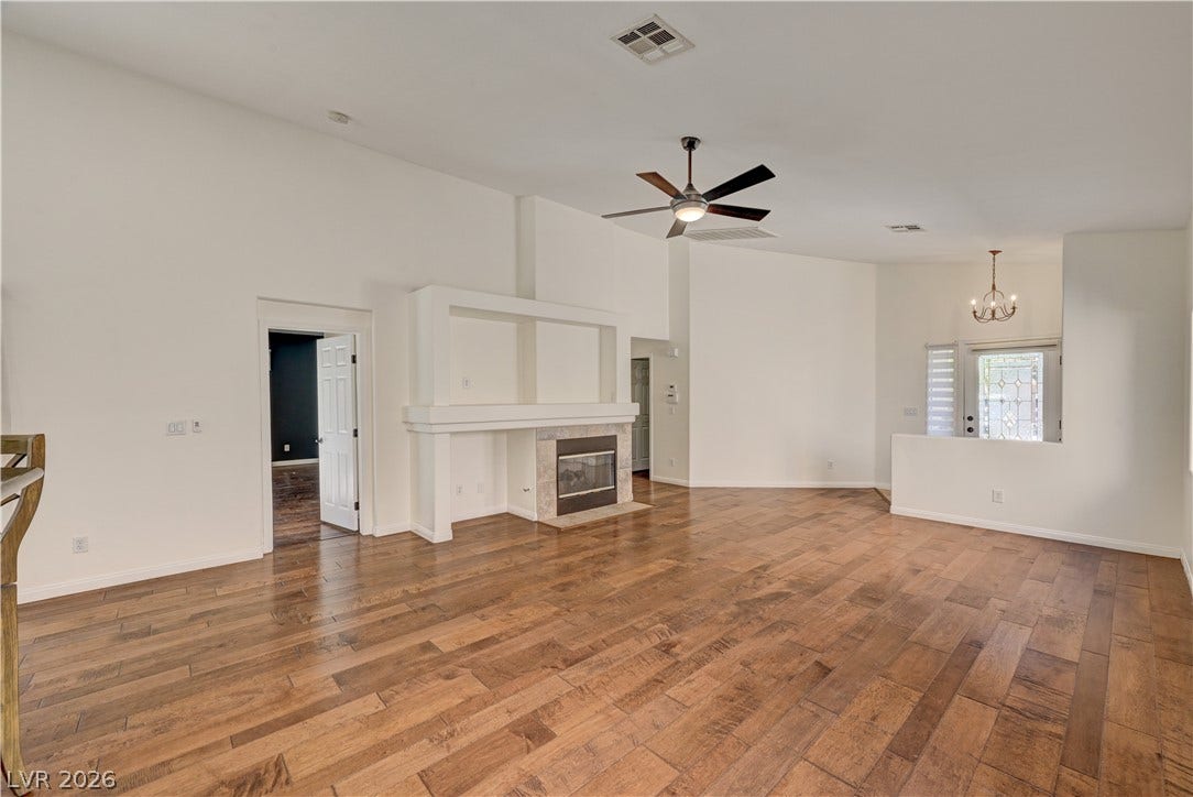 115 Cora Hills Court, Las Vegas, NV 89148 Hardwood floors and a central fireplace define this well-lit great room.