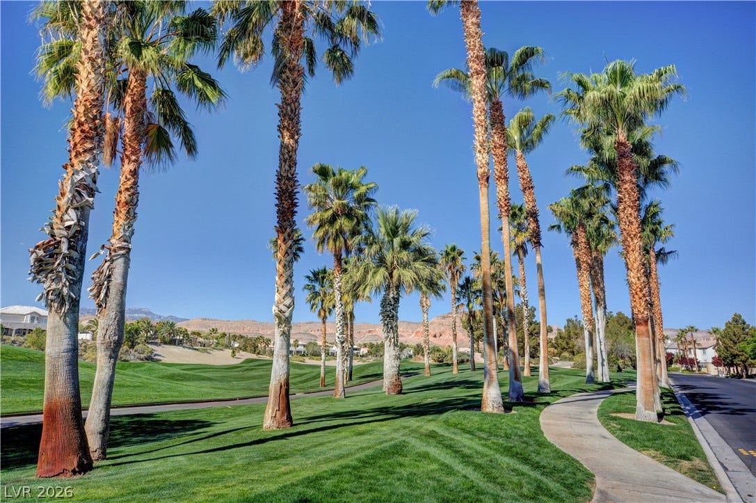 115 Cora Hills Court, Las Vegas, NV 89148 Mature palm trees line a winding pathway through lush green fairways.