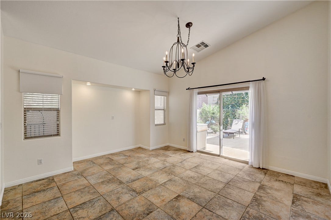 115 Cora Hills Court, Las Vegas, NV 89148 A grand chandelier illuminates this spacious living area, complete with vaulted ceilings and patio access.