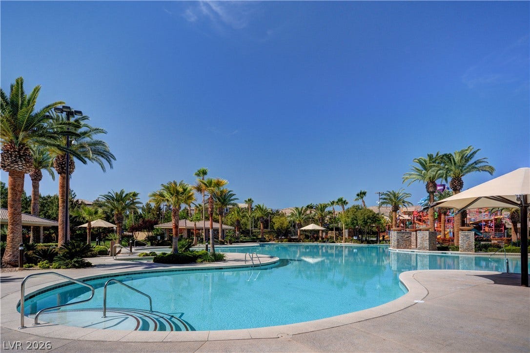 115 Cora Hills Court, Las Vegas, NV 89148 An oasis of refreshing waters awaits, framed by swaying palms under an endless blue sky.