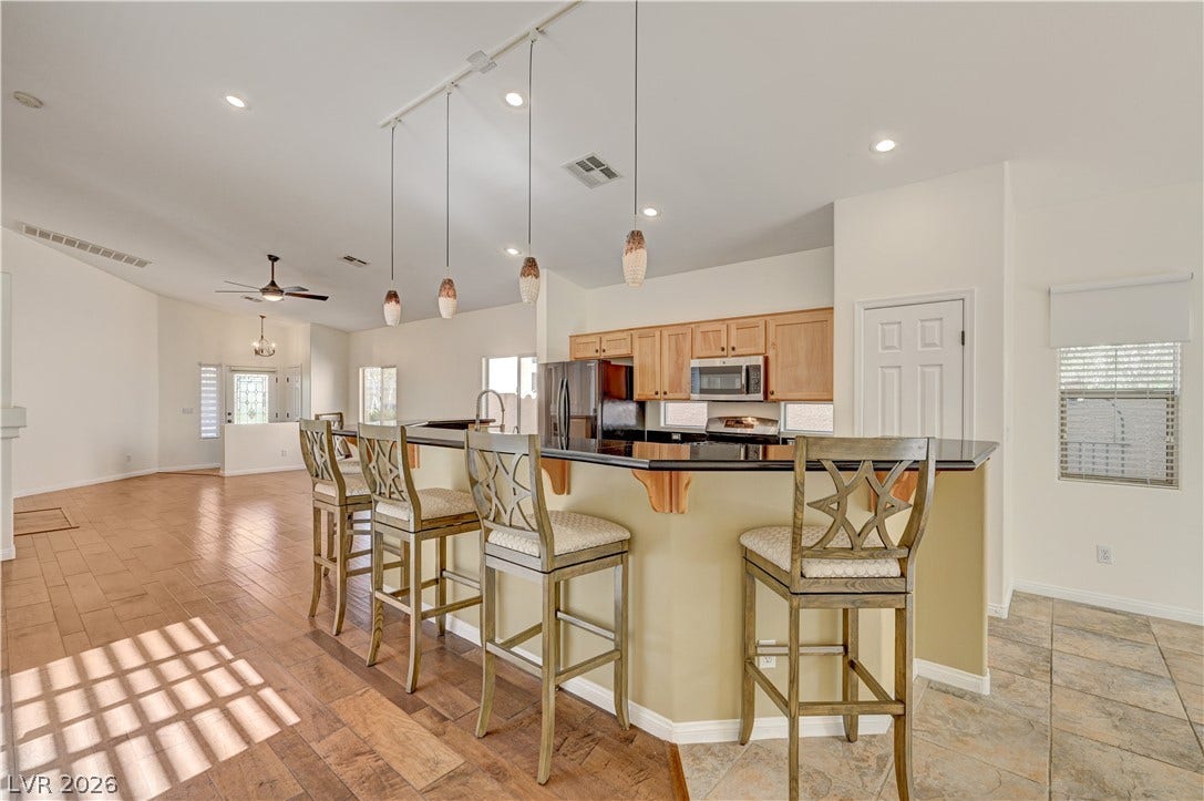 115 Cora Hills Court, Las Vegas, NV 89148 An inviting kitchen with a breakfast bar seamlessly connecting to an airy living space.
