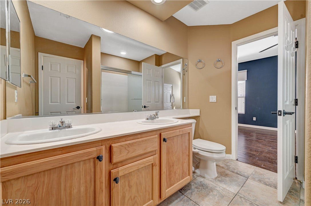 115 Cora Hills Court, Las Vegas, NV 89148 Double vanity and a tiled shower create a functional, inviting bathroom space.