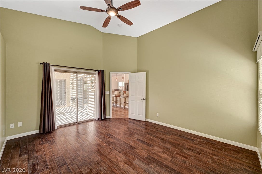 115 Cora Hills Court, Las Vegas, NV 89148 A well-lit living area features rich hardwood flooring, soaring ceilings, and convenient patio access.