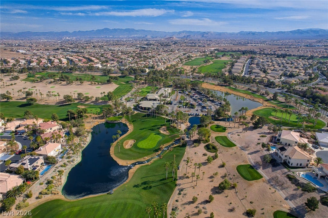 115 Cora Hills Court, Las Vegas, NV 89148 Aerial view of a sprawling golf course community nestled against a majestic mountain backdrop.