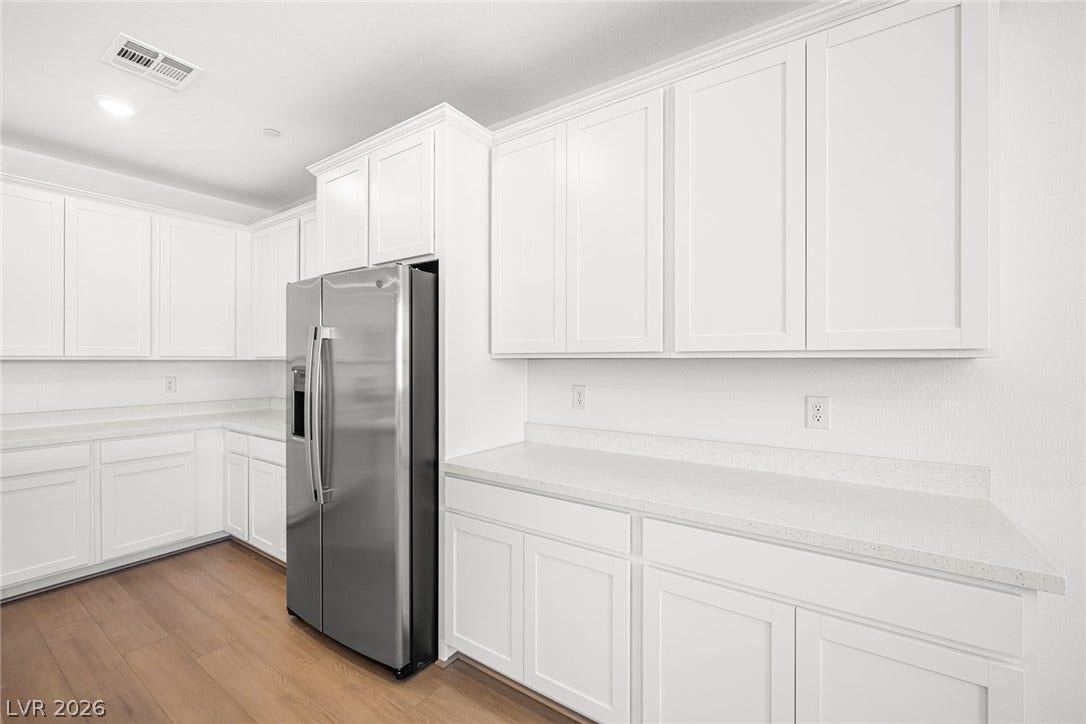 Bright white cabinetry and pristine countertops define this sleek, modern kitchen.