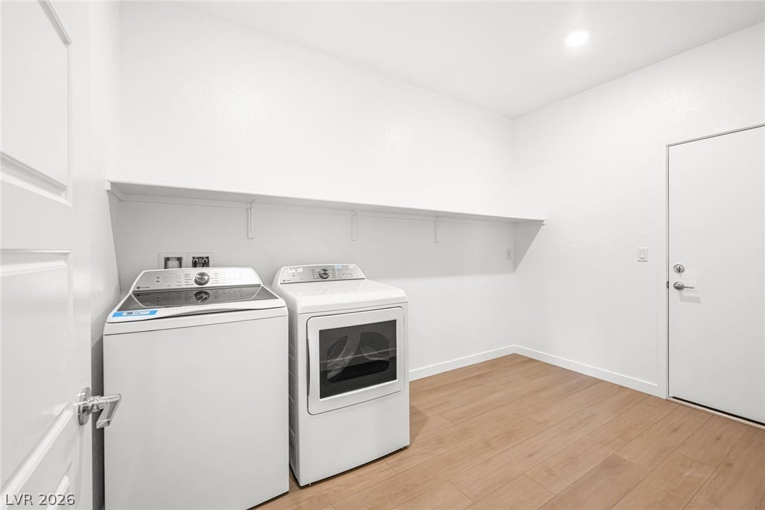 A dedicated laundry space offers convenience with ample shelving for storage.