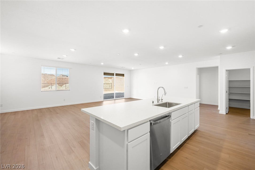 A well-lit open floorplan connects the kitchen island with the spacious living area.