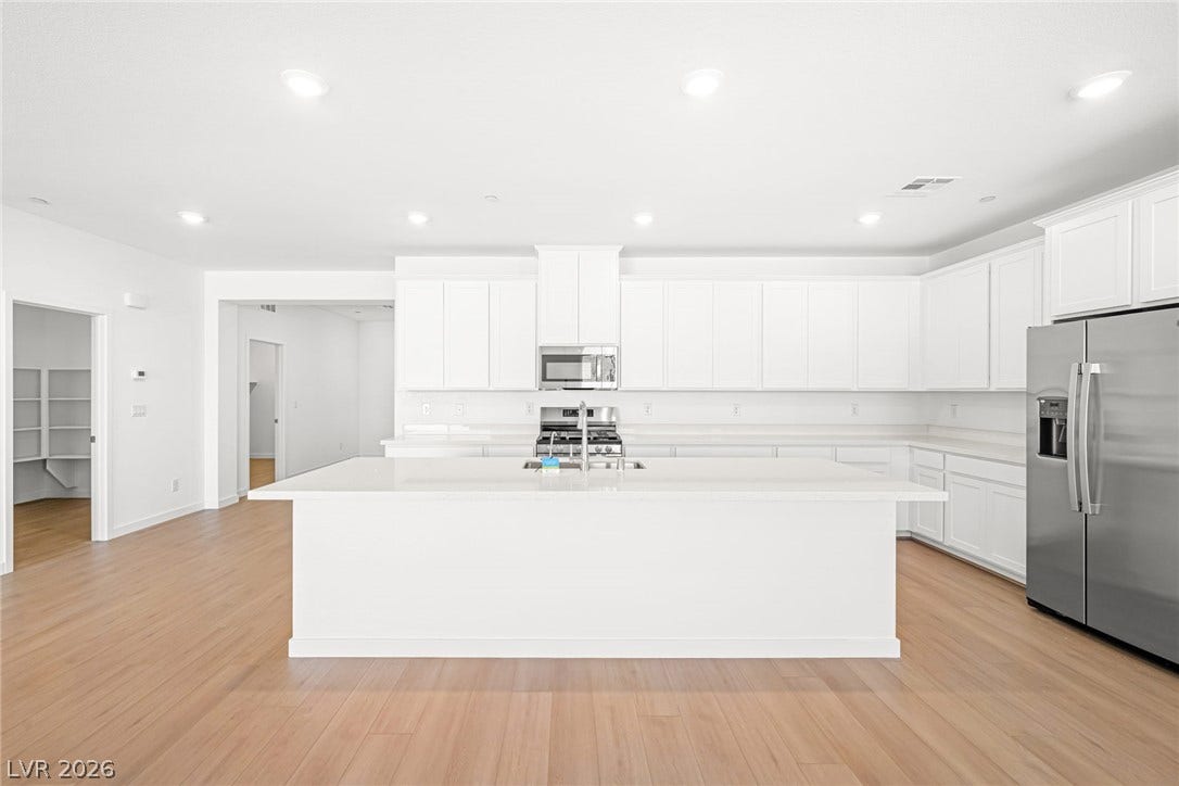 Culinary dreams come alive in this pristine kitchen with an inviting island and elegant recessed lighting.