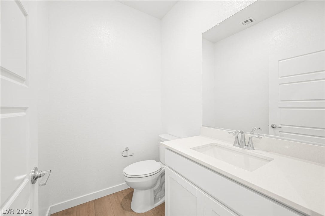 A pristine powder room with a sleek vanity and modern fixtures awaits guests.