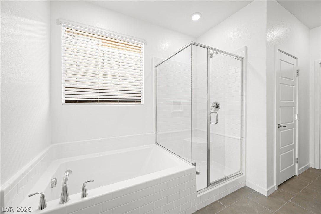 Indulge in a tranquil bathing experience with a generously sized tub and a sleek glass-enclosed shower.