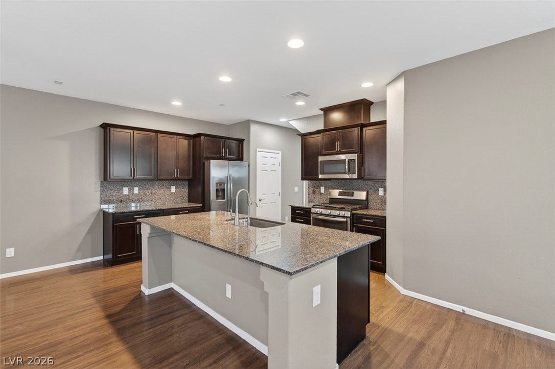 1146 Jesse Harbor Avenue, Henderson, NV 89014 A well-appointed kitchen showcasing an island with sink and rich wood cabinetry.