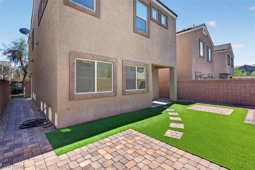 1146 Jesse Harbor Avenue, Henderson, NV 89014 A low-maintenance yard features artificial turf and elegant paver patios, ideal for outdoor leisure.