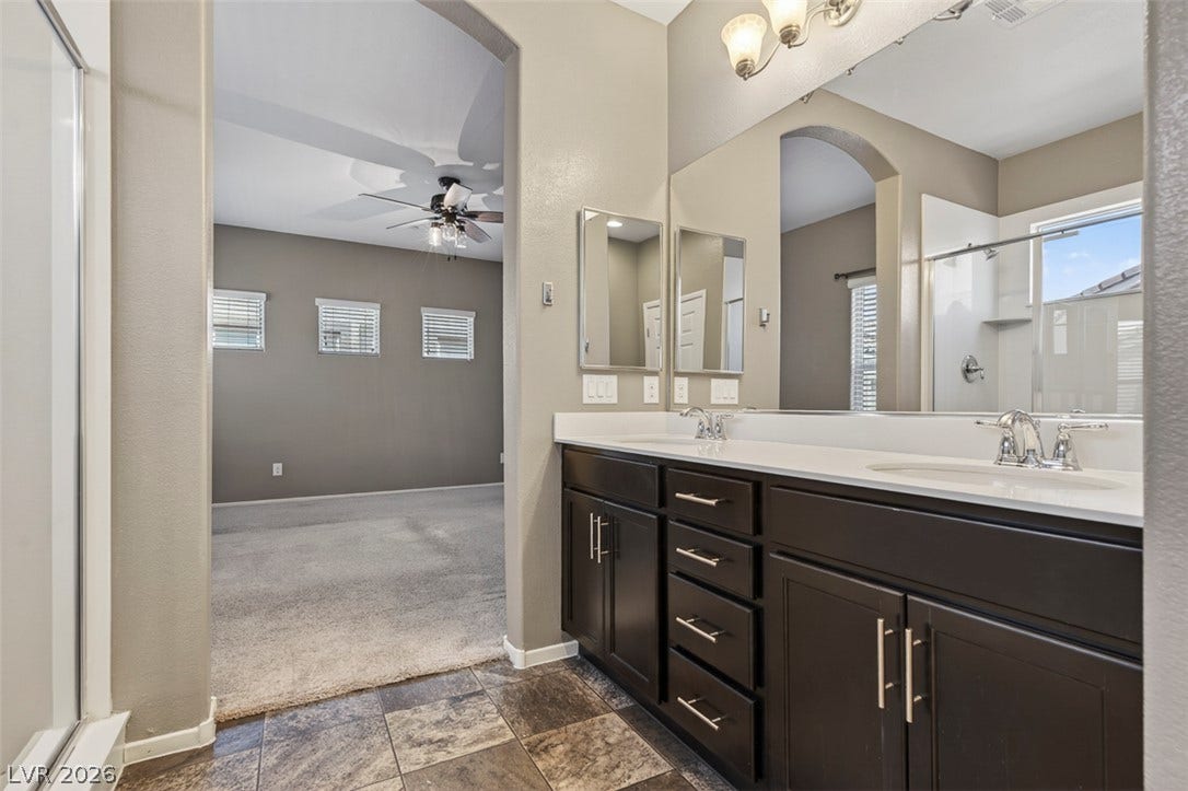 1146 Jesse Harbor Avenue, Henderson, NV 89014 Double vanities and a spacious shower offer everyday convenience in this connected primary bathroom.