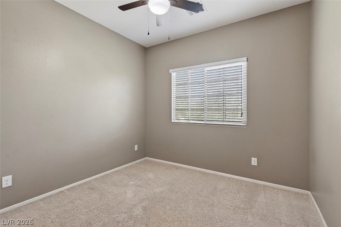 1146 Jesse Harbor Avenue, Henderson, NV 89014 A well-lit secondary bedroom features plush carpeting and a convenient ceiling fan for comfort.