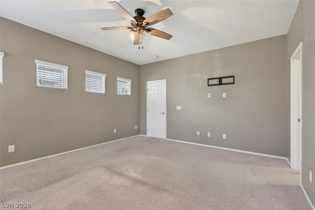 1146 Jesse Harbor Avenue, Henderson, NV 89014 A spacious room offers comfortable carpeting and a rustic-inspired ceiling fan.
