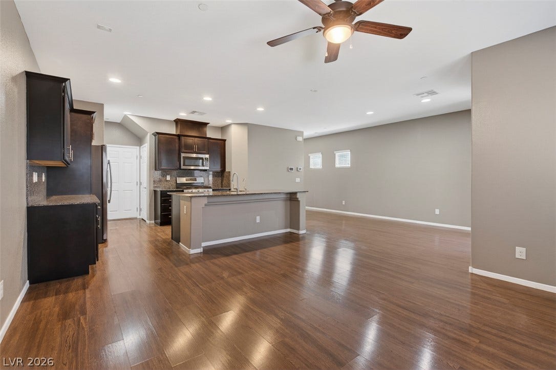 1146 Jesse Harbor Avenue, Henderson, NV 89014 An open-concept living area and kitchen with rich wood flooring creates a welcoming space for gatherings.