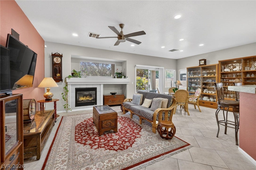 4467 Verdiccio Avenue, Las Vegas, NV 89141 A well-lit living space, featuring an inviting fireplace, tile flooring, and seamless access to outdoor leisure.