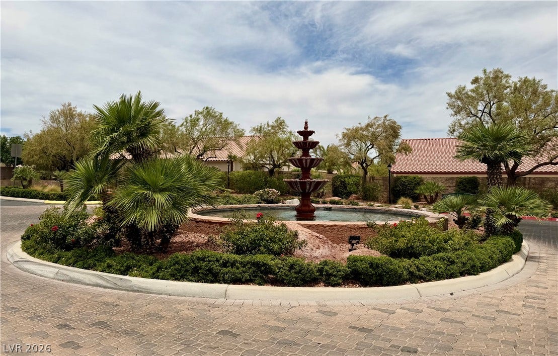 4467 Verdiccio Avenue, Las Vegas, NV 89141 A tiered water feature centers a lushly landscaped roundabout entrance to the neighborhood.