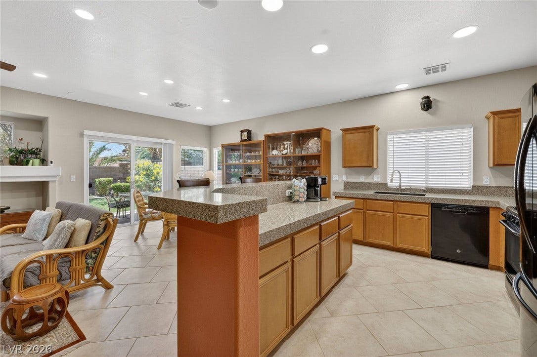 4467 Verdiccio Avenue, Las Vegas, NV 89141 Granite counters and recessed lighting elevate this well-appointed kitchen, flowing seamlessly into a bright outdoor area.