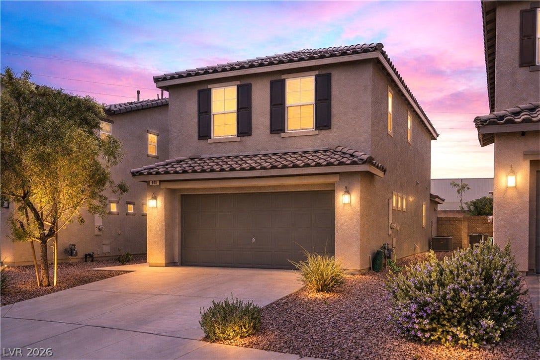 989 Harbor Avenue, Henderson, NV 89002 An inviting facade showcases well-lit landscaping and an attached garage