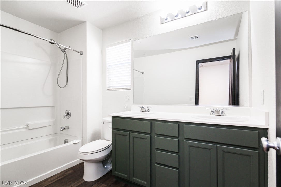 989 Harbor Avenue, Henderson, NV 89002 A well-lit bathroom features a spacious double vanity and a shower-tub combination.