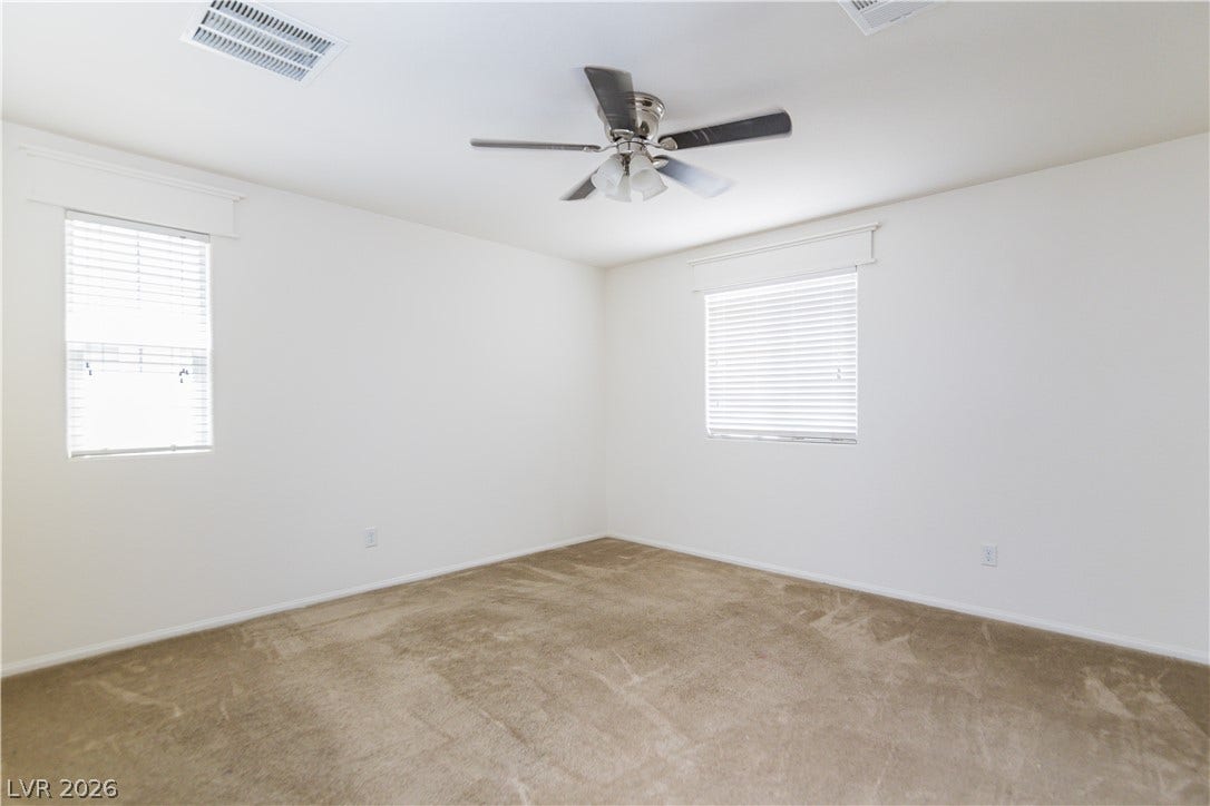 989 Harbor Avenue, Henderson, NV 89002 A well-lit bedroom offering a blank canvas for personalization, complete with a ceiling fan for comfort.