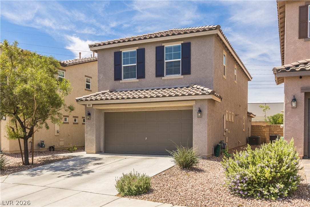 989 Harbor Avenue, Henderson, NV 89002 A welcoming facade presents a two-story home with an attached garage and well-maintained desert landscaping.