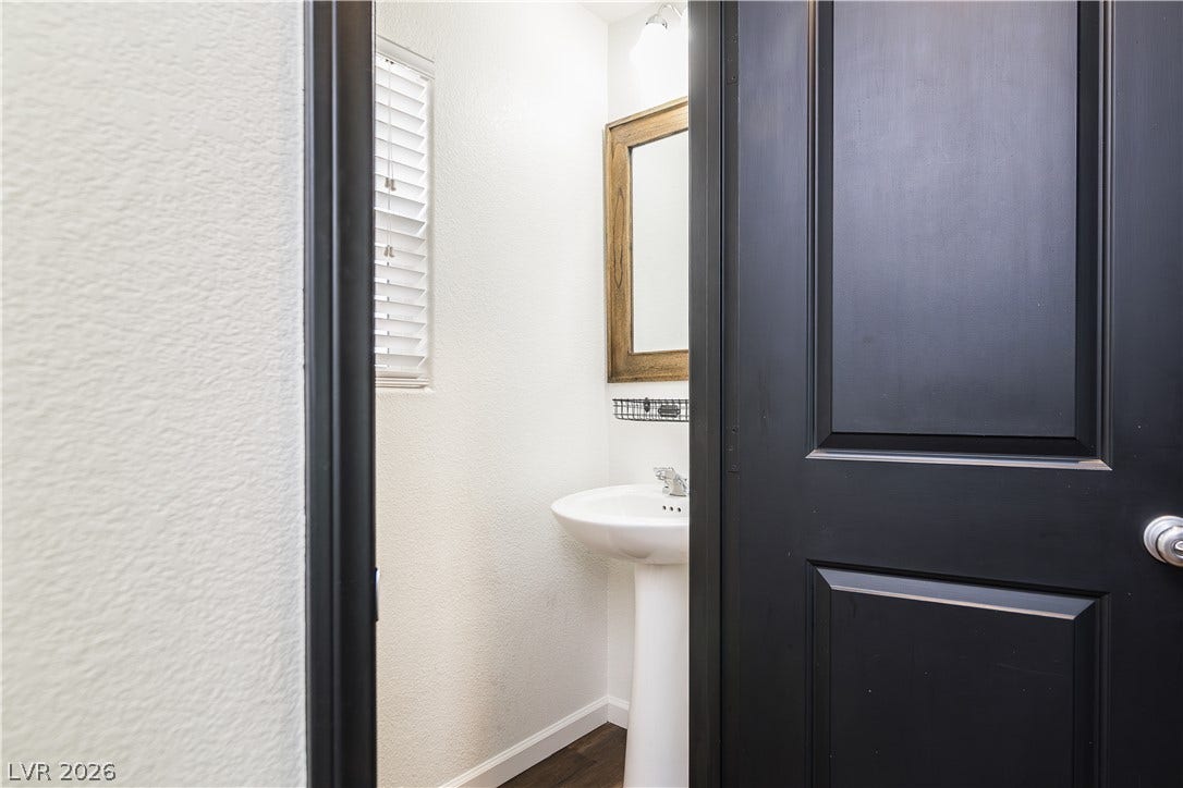 989 Harbor Avenue, Henderson, NV 89002 A well-appointed half bath features a pedestal sink and framed mirror, ideal for guest use.