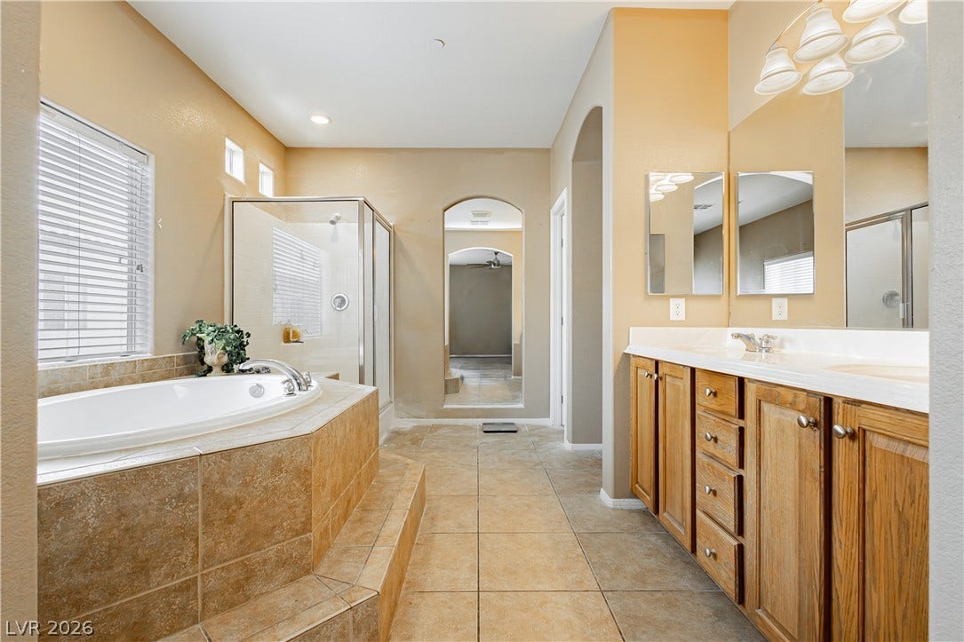 1176 Via Piazza, Henderson, NV 89052 Luxurious bathing quarters feature a spacious soaking tub, walk-in shower, and double vanity for ultimate relaxation.
