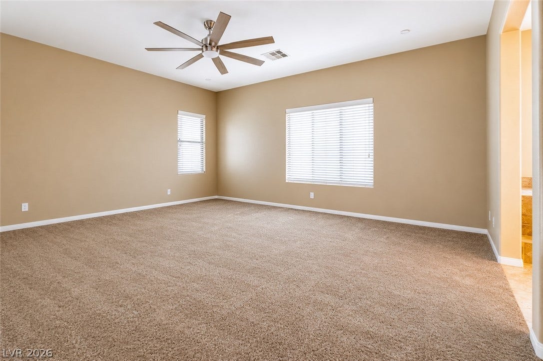 1176 Via Piazza, Henderson, NV 89052 An airy bedroom with dual windows and a modern ceiling fan for ultimate comfort.