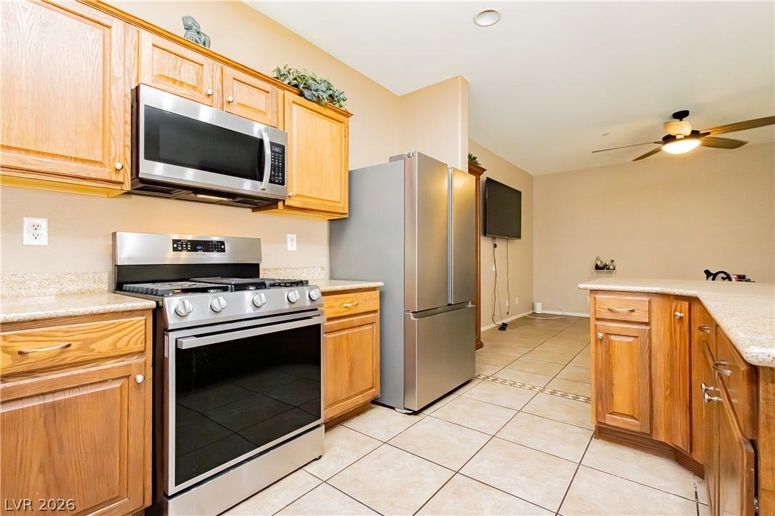 1176 Via Piazza, Henderson, NV 89052 Culinary delights await in this modern kitchen, featuring sleek stainless steel appliances and abundant cabinetry.