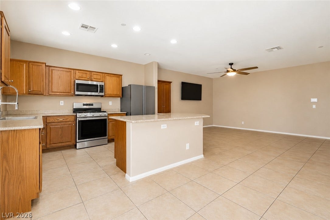 1176 Via Piazza, Henderson, NV 89052 An open-concept living area boasts a modern kitchen with a convenient island and integrated appliances.