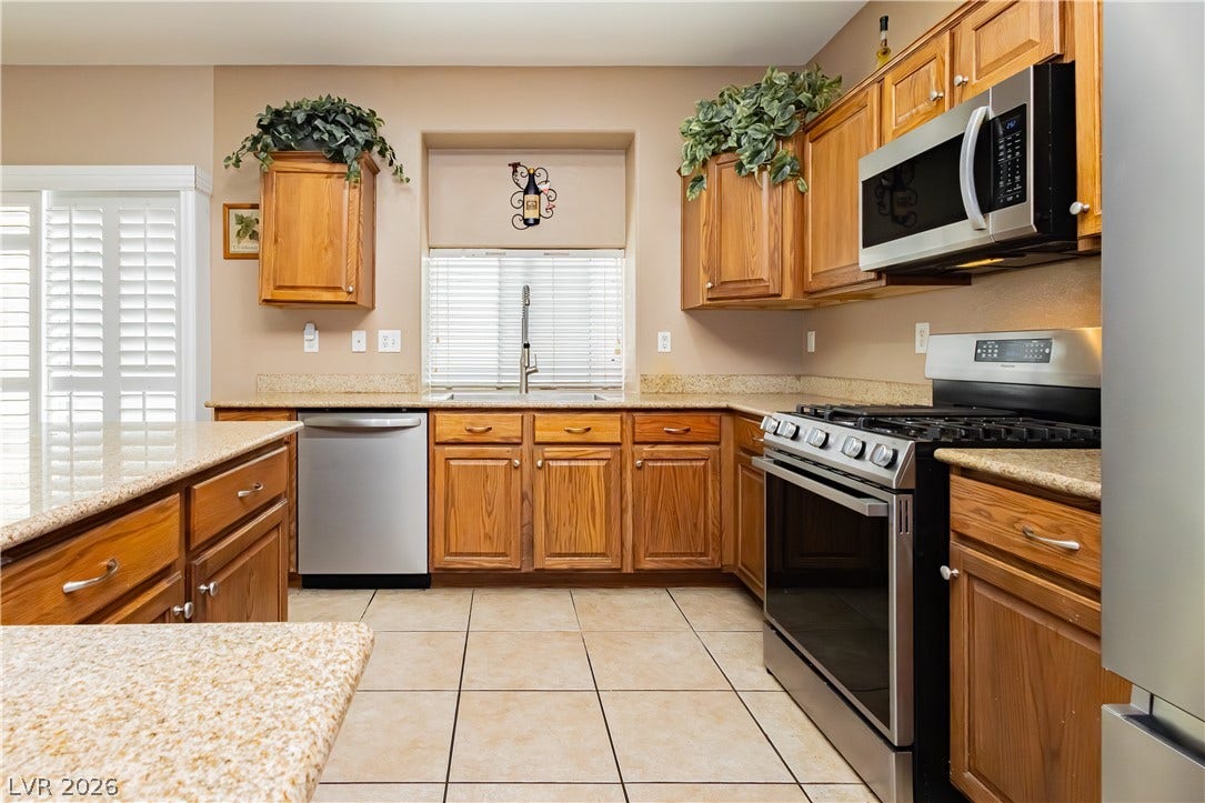 1176 Via Piazza, Henderson, NV 89052 This kitchen showcases durable tile flooring, wood cabinetry, and a full suite of stainless steel appliances.