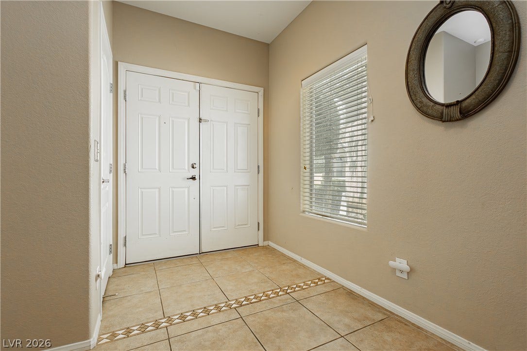 1176 Via Piazza, Henderson, NV 89052 A welcoming entry featuring a double front door, natural light, and tile flooring.