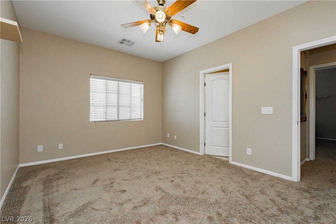 1176 Via Piazza, Henderson, NV 89052 A well-lit bedroom features plush carpeting and a convenient ceiling fan for ultimate comfort.