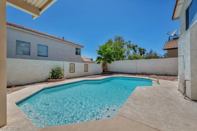 2553 Hummingbird Hill Avenue, Henderson, NV 89074 An inviting backyard oasis offers a crystal-clear swimming pool, perfect for sunny relaxation.
