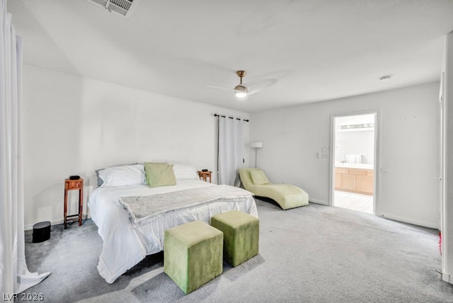 2553 Hummingbird Hill Avenue, Henderson, NV 89074 A quiet bedroom with light carpeted flooring and a convenient entry to a well-appointed bathroom.