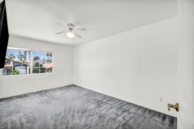 2553 Hummingbird Hill Avenue, Henderson, NV 89074 A well-proportioned space features plush carpet, a ceiling fan, and a wide window offering neighborhood views.