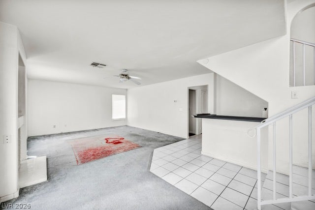 2553 Hummingbird Hill Avenue, Henderson, NV 89074 A versatile living area with a ceiling fan, offering both carpeted comfort and tiled transitions.